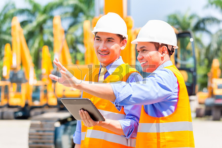 33784280-asian-engineer-controlling-construction-machinery-of-construction-site-or-mining-company